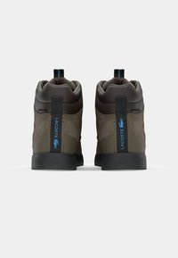 Brown and gray suede high-top sneakers with black rubber soles. Features blue logo accents, padded collar, and pull tabs.