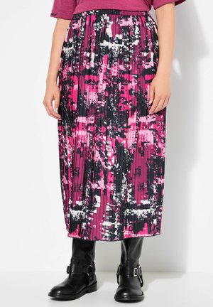 Faltender Midirock in pink-schwarz-weißer abstrakter Druck. Mit elastischem Bund und strukturiertem Stoff. Getragen mit schwarzen knielangen Stiefeln.