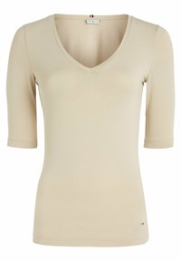 Beige V-neck t-shirt with three-quarter sleeves, made of smooth fabric, featuring subtle stitching details and a small logo accent at the hem.