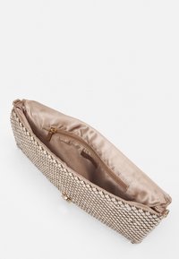 Bolso de mano tejido en color beige con un exterior texturizado y un interior de satén suave. Cuenta con un bolsillo con cremallera y un cierre metálico.