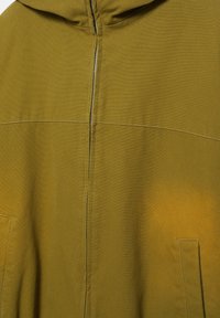 Olivově zelená mikina s kapucí se zadním zipem a viditelnými švy, zobrazuje horní část trupu a okraje kapes.