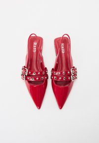 Tacchi slingback in vernice rossa con punta affusolata e cinturini con fibbie argentate featuring accenti metallici circolari. Logo del brand all'interno.
