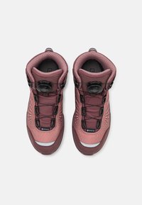 Scarpe da trekking GORE-TEX in rosa polveroso con pannelli testurizzati, hardware nero e sistema di allacciatura a manopola. Presentano colletto imbottito e accenti riflettenti.