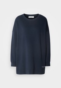 Sudadera azul marino hecha de tela suave, con un escote redondo, mangas largas y un dobladillo recto con una pequeña etiqueta de marca en la parte inferior.