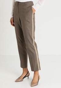 Bruna rutiga byxor med skräddarsydd passform, med en sidostrimma. Tillverkade av ett texturerat tyg med en slät yta.