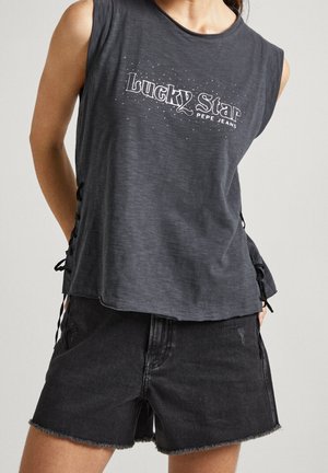 Ærmeløs mørkegrå top med teksten "Lucky Star PEPE JEANS", kombineret med sorte denimshorts med frynset kant, båret af en stående person.