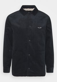 Sort kordfløjlsjakke med blødt for, knaplukning foran, to frontlommer og Volcom-logo. Har ribbet tekstur og krave.