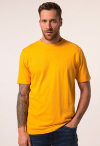 Gul crew neck t-shirt i bomuldsstof, korte ærmer, med slim fit. Har et diskret logo på brystet. Enkel design.