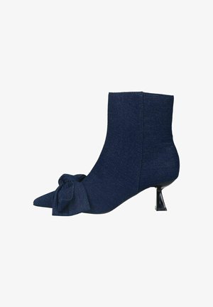 Navy blue fabric ankle boots with a pointed toe, featuring a side bow detail and a short, sleek black heel. Smooth texture.