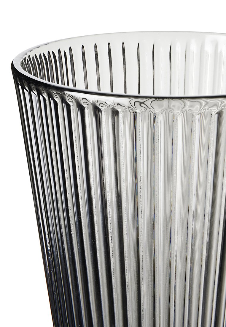 Klarer Glasvase mit vertikaler gerippter Struktur, die eine konische Form und einen glatten oberen Rand aufweist. Licht bricht durch das durchscheinende Material.