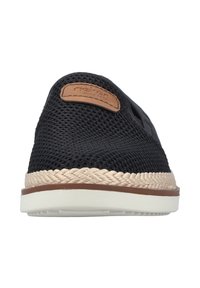 Zapato negro de malla sin cordones con parche de cuero marrón y detalle tejido tipo yute en la suela, con una base de goma blanca.