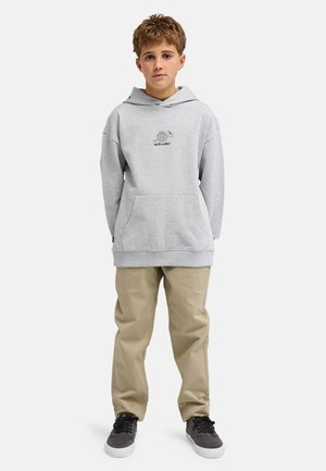 Szara bluza z kapturem z przednią kieszenią i detalem z logo, w połączeniu z beżowymi spodniami i czarnymi trampkami. Swobodny, luźny krój i miękka tekstura.