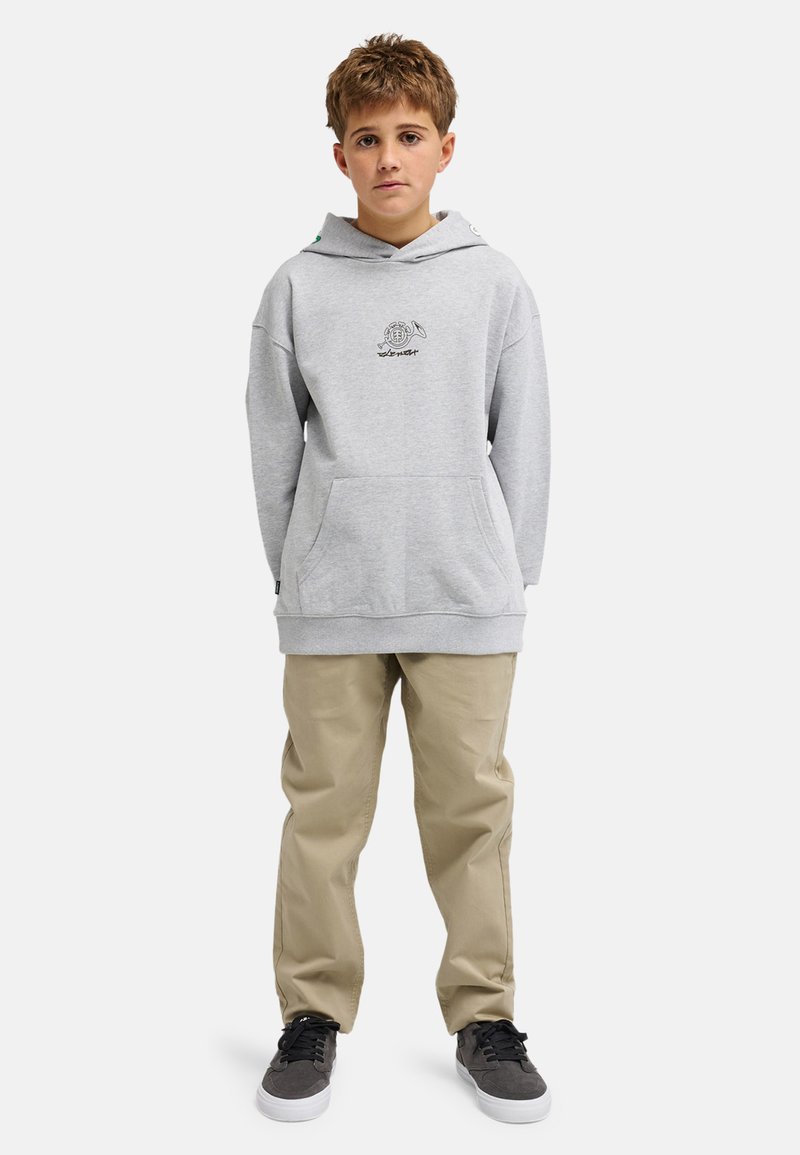 Grauer Kapuzenpullover mit einer Fronttasche und Logodetail, kombiniert mit beigen Hosen und schwarzen Sneakern. Lässiger, entspannter Schnitt und weiche Textur.