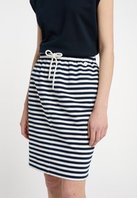Csíkos pamut szoknya sötétkék és fehér színben, elasztikus derékrésszel és zsinórral. Slim fit szabású, puha tapintású.