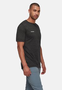 Grijze t-shirt met korte mouwen, gemaakt van zachte, gestructureerde stof. Bevat een klein wit "MAMMUT" logo op de borst.
