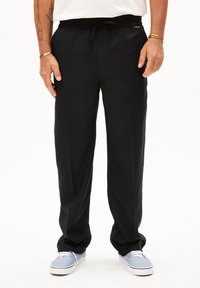 Zwarte, lichte, relaxed-fit broek met een elastische tailleband en trekkoord. De stof heeft een gladde textuur en zijzakken.