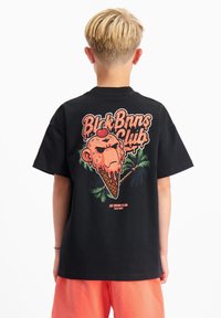 Zwarte katoenen t-shirt met een kleurrijke afbeelding van een ijsje en een cartoonfigur op de achterkant, met palmbomenaccenten en vetgedrukte tekst.