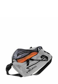 Sac de sport gris avec des accents noirs et une poche en filet. Comprend une large ouverture, des sangles solides et un logo imprimé sur le côté.