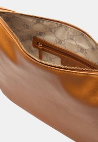 Borsa in pelle marrone con finitura testurizzata. L'interno presenta una fodera con motivo e una tasca con cerniera. Chiusura con cerniera lungo il bordo superiore.