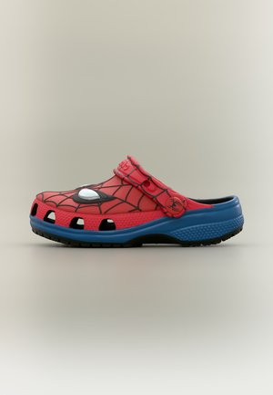 Sabot enfant rouge et bleu à enfiler avec motif toile noire, graphisme œil blanc et bride réglable avec emblème d'araignée.