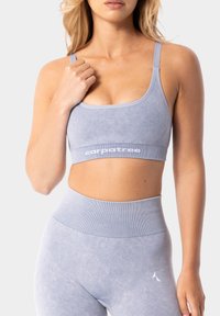 Gaiši zils sporta krūšturis ar gludu tekstūru, aprīkots ar platām siksnām ar "carpatree" zīmola logo. Dizainu noslēdz regulējamas plānas siksnas.