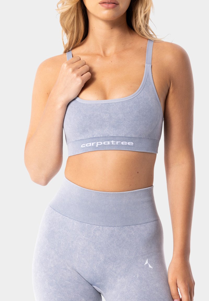 Gaiši zils sporta krūšturis ar gludu tekstūru, aprīkots ar platām siksnām ar "carpatree" zīmola logo. Dizainu noslēdz regulējamas plānas siksnas.