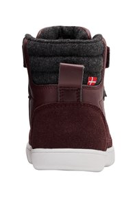 Sneaker alta color bordeaux con collo in feltro, suede testurizzato, linguetta imbottita e suola in gomma bianca con chiusura laterale in Velcro.