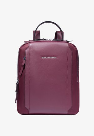 Mochila de cuero color granate con un diseño estructurado, asas dobles y cierre de cremallera. Presenta un logo sutil y un bolsillo lateral. Textura suave.