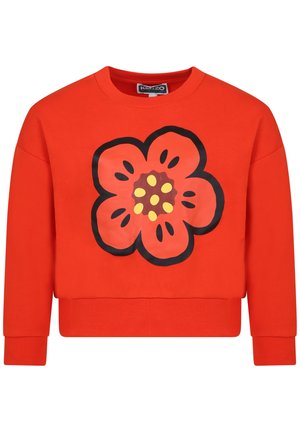Felpa rossa realizzata in morbido cotone con una grande stampa di un fiore contornato di nero al centro, con punti gialli al centro del fiore.