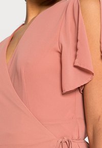 Różowa sukienka kopertowa z krótkimi falbanowymi rękawami, wykonana z miękkiego materiału. Posiada głęboki dekolt w kształcie litery V oraz wiązany pas dla regulowanego dopasowania.