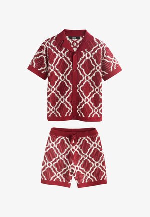 Camicia rossa a maniche corte con bottoni e pantaloncini abbinati con motivo a catena geometrica bianca, colletto, polsini e fascia in vita a coste.