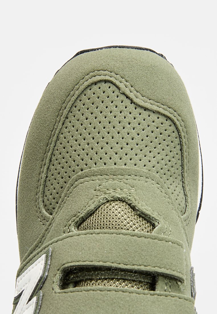 Baskets en daim vert avec des accents en maille, zone des orteils perforée et sangles Velcro. Présente des détails de logo et une semelle noire unie.