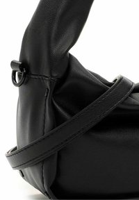 Sac à main en cuir noir doux avec poignée incurvée et bandoulière réglable, présentant des coutures apparentes et une attache en anneau métallique.