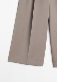 Graue weit geschnittene Hose aus glattem Stoff, mit einem schlichten Design ohne sichtbare Muster oder Akzente. Gefalteter Saum am unteren Ende.