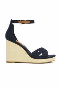 Navy canvas wedge sandals with a woven jute heel, cross strap design, ankle strap with a brown buckle, and a small logo accent.