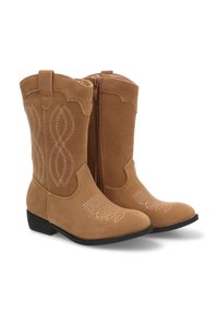 Botines de gamuza color marrón claro con una textura suave, que presentan costuras decorativas blancas y una cremallera lateral para facilitar su uso. Suela plana negra.