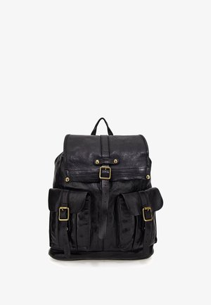 Zaino in pelle nera con pattina e chiusure con fibbia, due tasche frontali con fibbie e una maniglia superiore.