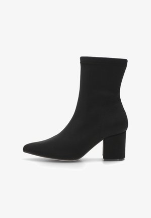Botín negro de tobillo hecho de tela suave, con puntera afilada y tacón cuadrado. Textura lisa y diseño sin costuras.