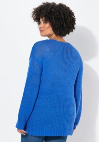 Maglione blu lavorato a maglia con una vestibilità ampia, maniche lunghe e un motivo testurizzato. Progettato con un collo arrotondato e spalle basse.