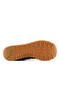 Semelle d’une chaussure marron à semelle en caoutchouc avec des sculptures profondes et le logo New Balance, présentée à plat sur fond blanc.
