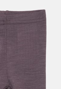 Ribbestrømpebukser i en dempet lilla farge. Myk, elastisk midje med en glatt tekstur. Ingen synlige mønstre eller detaljer.
