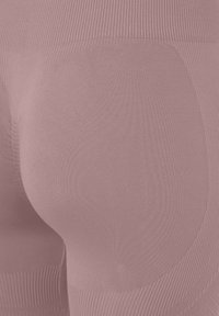 Pink seamless leggings featuring a ribbed waistband, smooth texture, and contoured design for shaping, highlighting curves without seams.