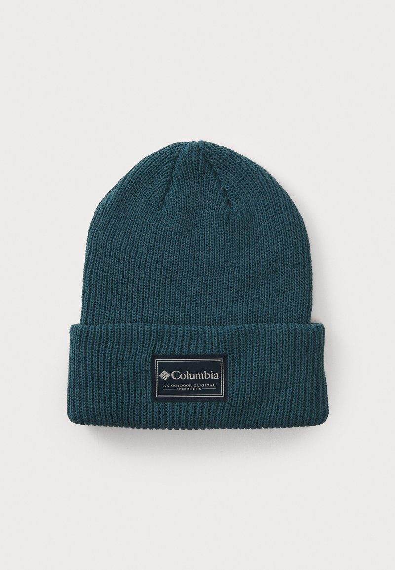 Blue knitted beanie with a ribbed texture, folded cuff, and a rectangular black label featuring white text and logo.