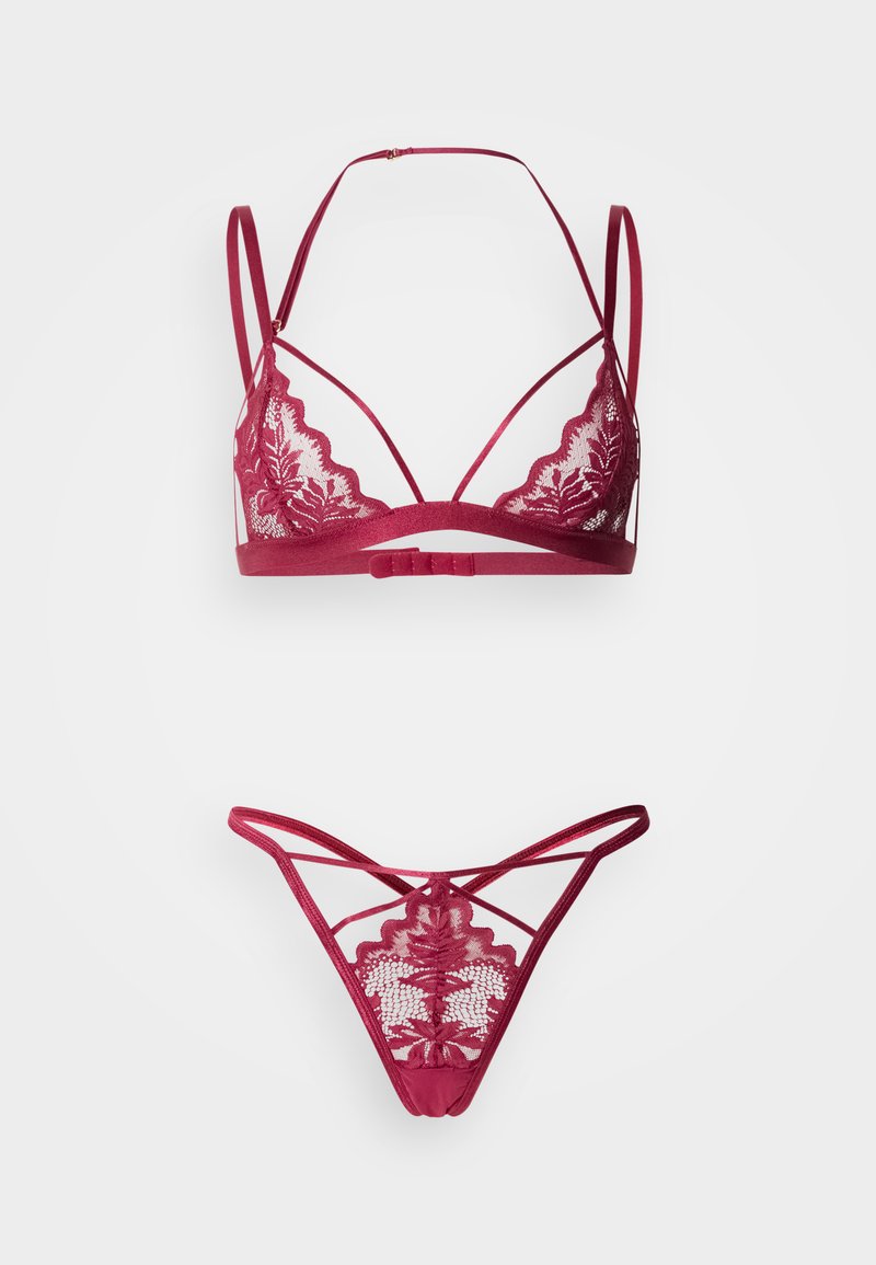 Μπορντό δαντελένιο σουτιέν bralette με κυματιστές άκρες και ρυθμιζόμενους ιμάντες, σε συνδυασμό με τριγωνικό δαντελένιο εσώρουχο με διασταυρούμενες λεπτομέρειες.