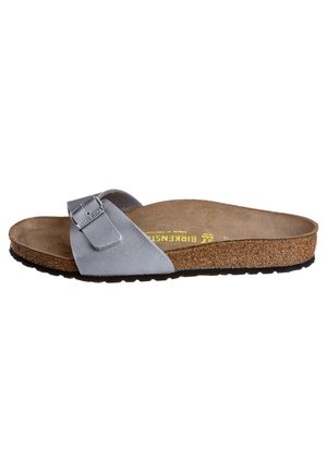 Sandal a slide in pelle grigia con fibbia metallica regolabile, soletta in sughero e suola in gomma. Design piatto con accenti minimalisti.