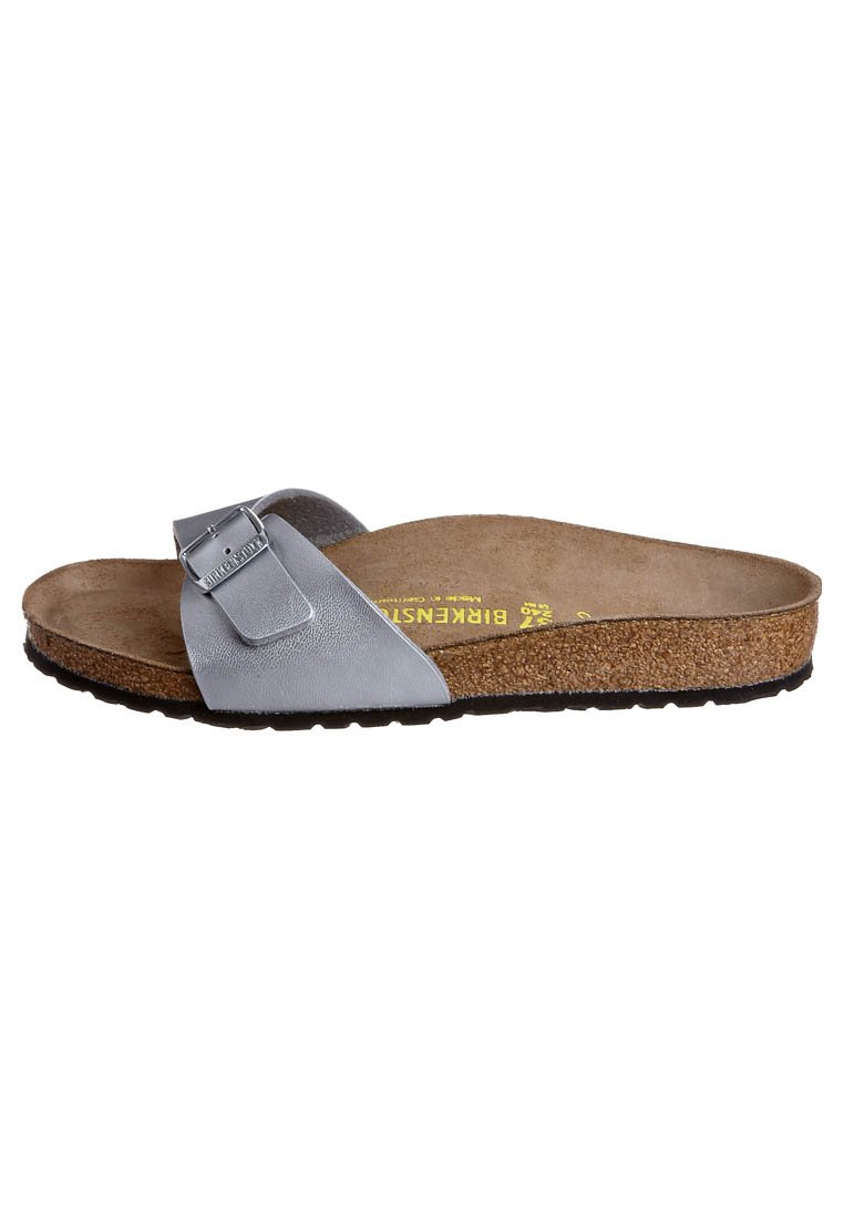 Sandal a slide in pelle grigia con fibbia metallica regolabile, soletta in sughero e suola in gomma. Design piatto con accenti minimalisti.