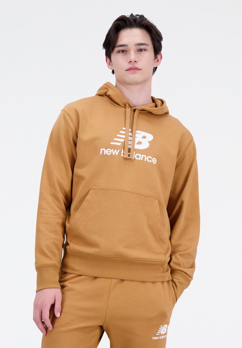 Sudadera marrón de tejido suave con un bolsillo canguro y puños acanalados. Presenta un logo blanco de "New Balance" en la parte delantera.