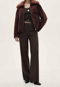 Brown suede jacket with a fur collar, paired with brown wide-leg trousers. Textured fabric and fitted style with minimalist design details.