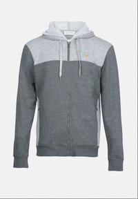 Grå hettegenser med glidelås som har et lys grått panel over brystet, justerbar snorhette og brodert logo øverst til venstre.
