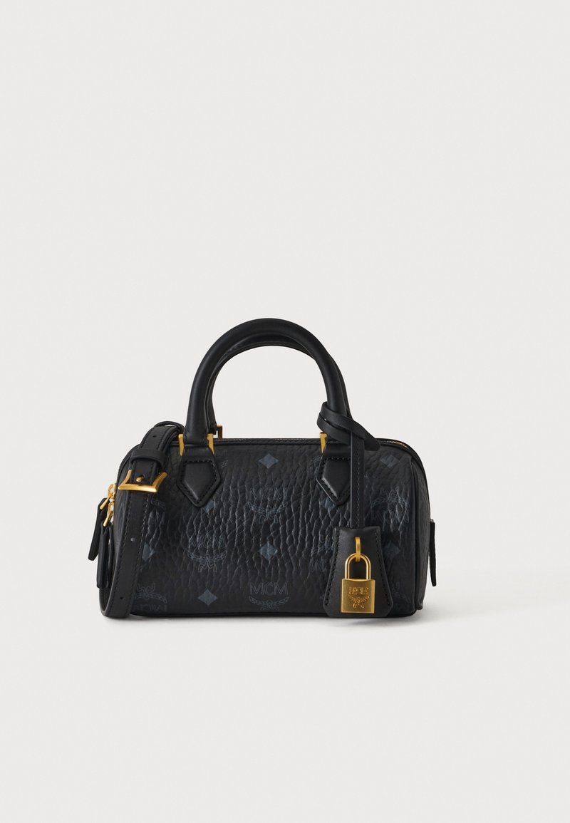 Sac à main en cuir noir texturé avec double poignée, fermeture dorée, bandoulière réglable et logos embossés subtils sur un fond uni.